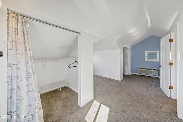 spacious closet with vaulted ceiling, light carpet, and a wall unit AC