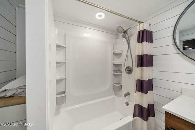 bathroom with vanity, wooden walls, and shower / tub combo