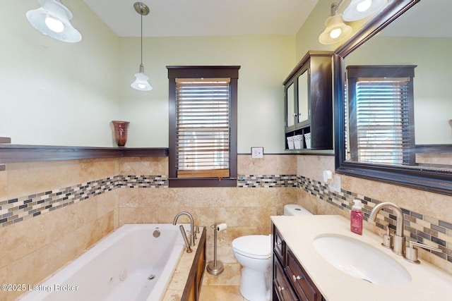 bathroom with a washtub, tile patterned flooring, tile walls, vanity, and toilet