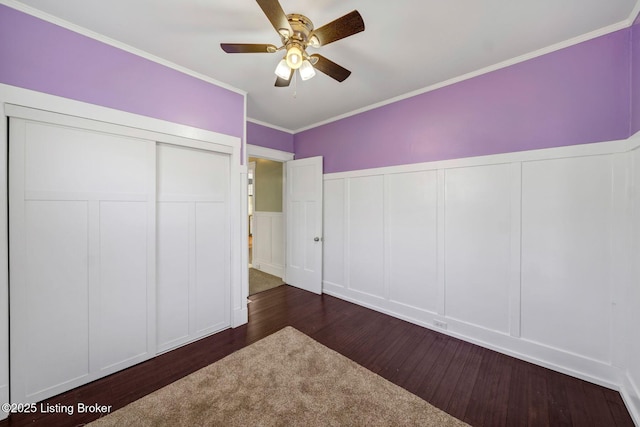 unfurnished bedroom featuring crown molding, dark wood-type flooring, and ceiling fan