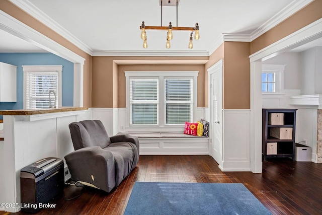 sitting room with crown molding, dark wood-type flooring, and a healthy amount of sunlight