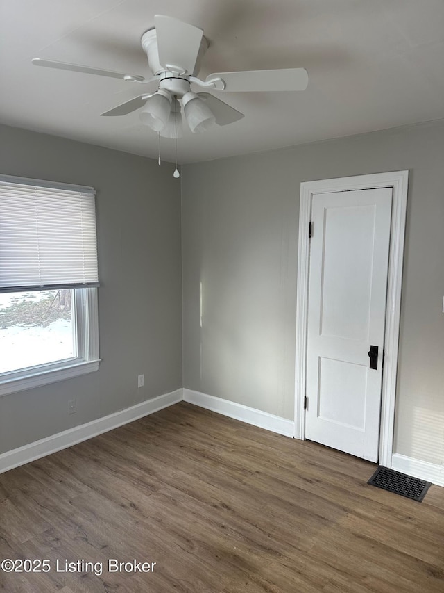 empty room featuring dark hardwood / wood-style floors and ceiling fan