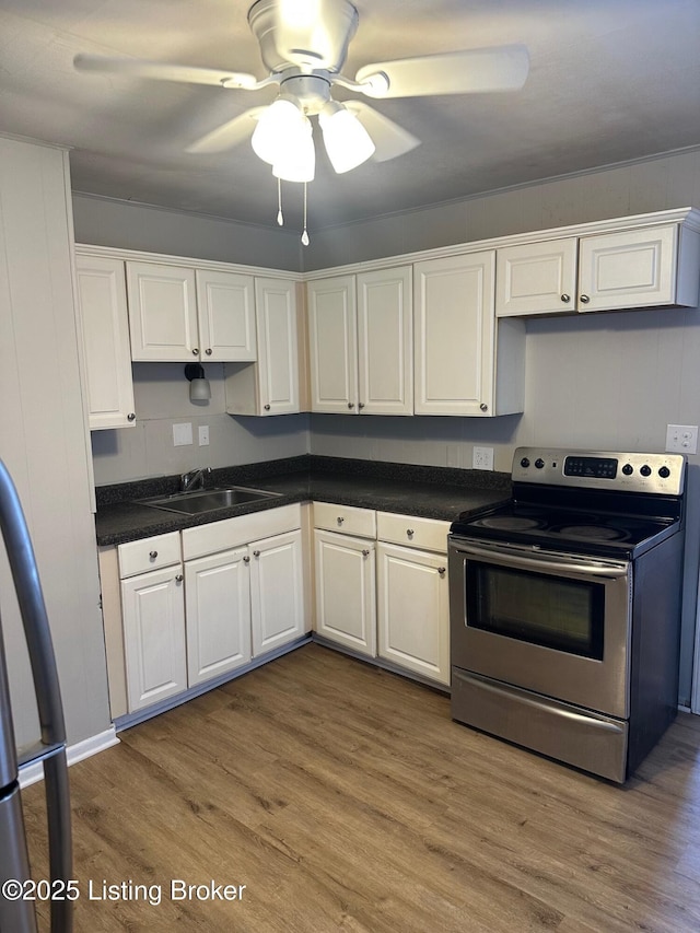 kitchen with appliances with stainless steel finishes, white cabinetry, sink, ceiling fan, and light wood-type flooring