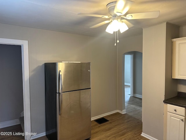 kitchen with white cabinetry, dark hardwood / wood-style floors, ceiling fan, and stainless steel refrigerator