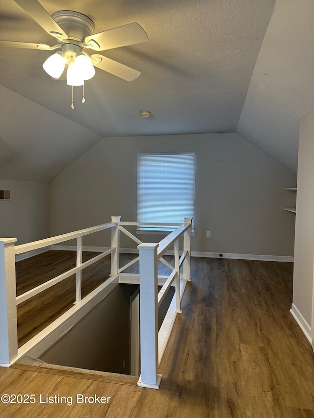 bonus room with vaulted ceiling, dark hardwood / wood-style floors, and a textured ceiling