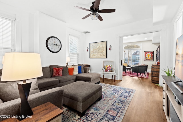 living room featuring ceiling fan and light hardwood / wood-style floors