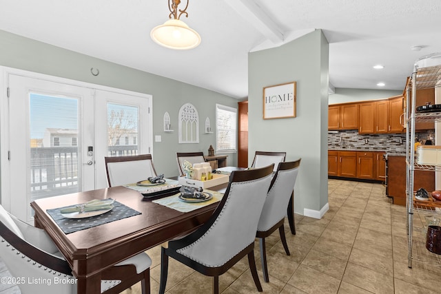 dining room featuring french doors, lofted ceiling with beams, and light tile patterned floors