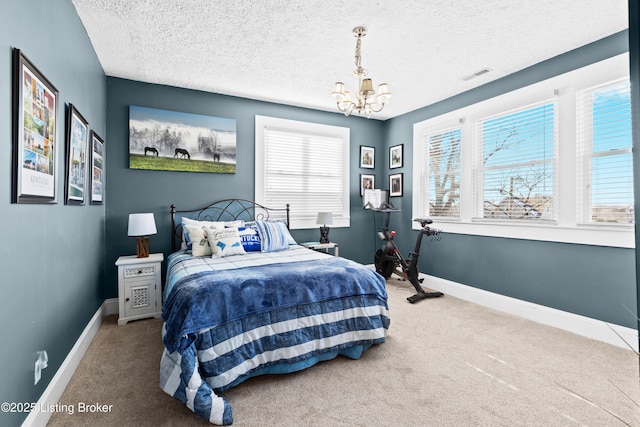 carpeted bedroom featuring a textured ceiling and a notable chandelier