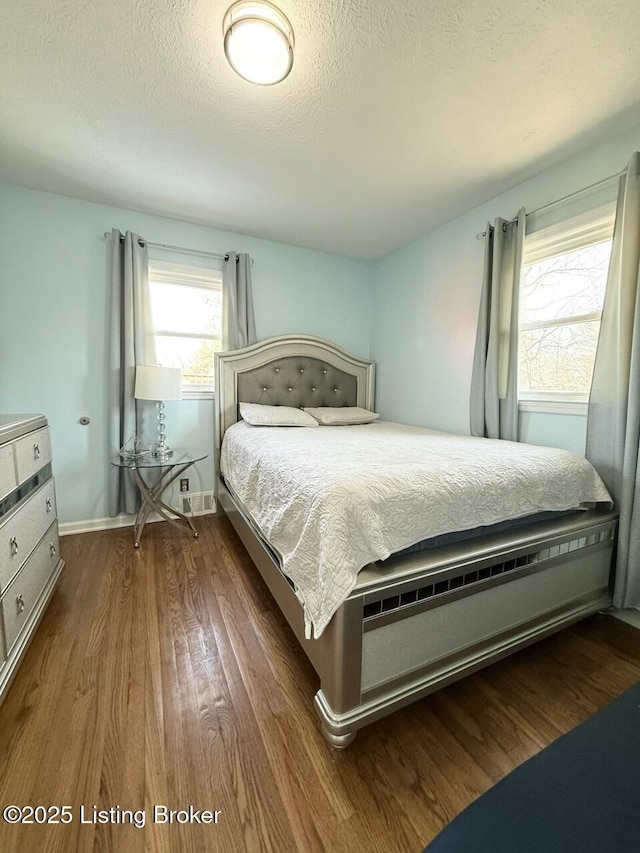 bedroom with dark wood-type flooring and a textured ceiling