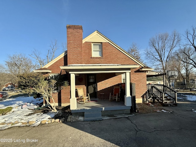 rear view of property featuring covered porch