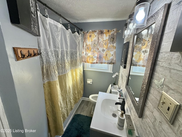 bathroom with hardwood / wood-style flooring, vanity, a textured ceiling, toilet, and walk in shower