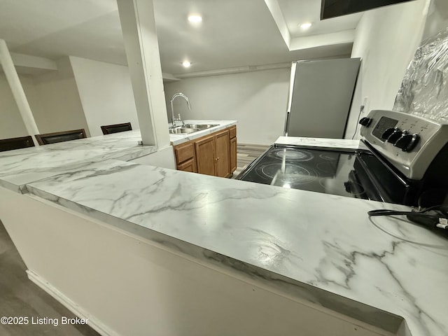 kitchen with sink, kitchen peninsula, a kitchen bar, and electric stove