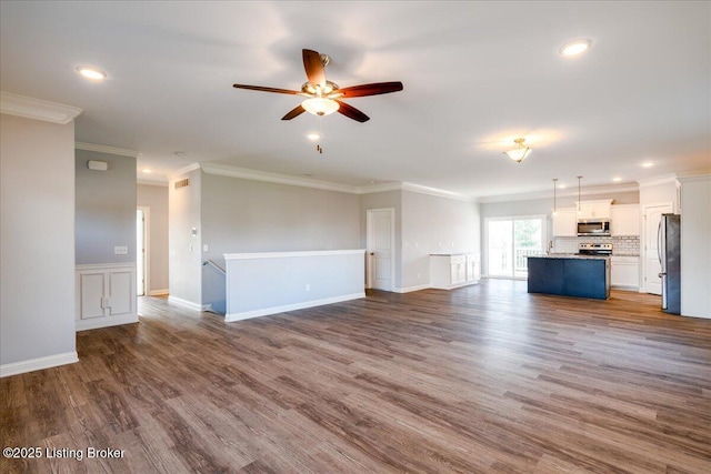 unfurnished living room featuring ceiling fan, ornamental molding, and wood-type flooring