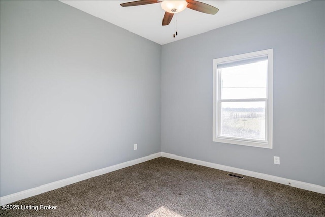 carpeted spare room featuring a wealth of natural light and ceiling fan