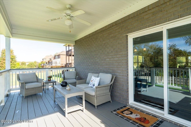 wooden deck featuring outdoor lounge area and ceiling fan