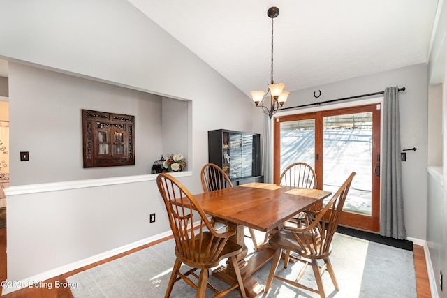 dining room with vaulted ceiling, a chandelier, and light hardwood / wood-style floors