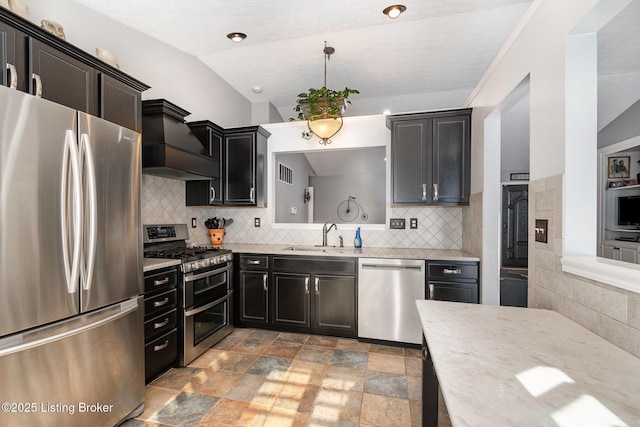 kitchen featuring appliances with stainless steel finishes, pendant lighting, sink, decorative backsplash, and custom exhaust hood