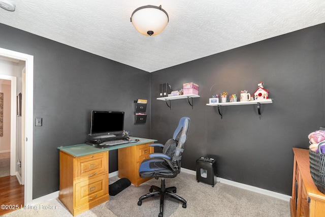 carpeted home office with a textured ceiling