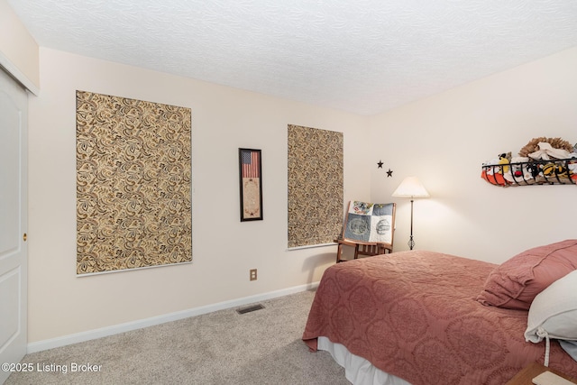 bedroom featuring light colored carpet and a textured ceiling