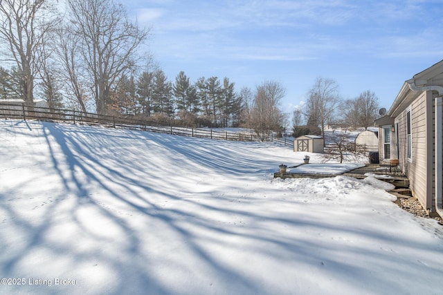 yard layered in snow with a storage unit