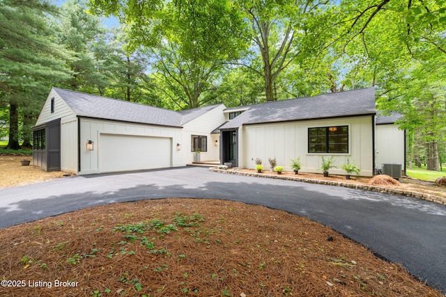 view of front of property with a garage and central AC unit