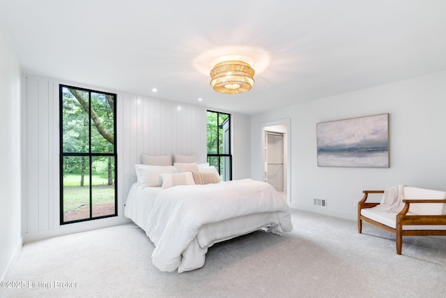 bedroom with multiple windows and light colored carpet