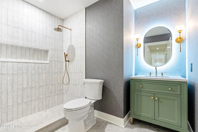 bathroom with vanity, tile patterned floors, toilet, and tiled shower