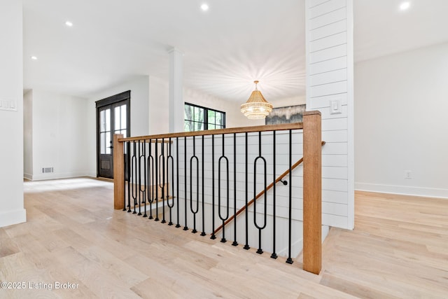 hallway featuring an inviting chandelier and light wood-type flooring