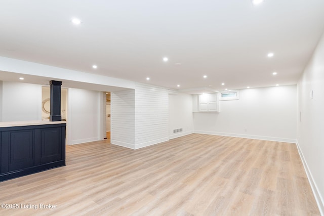 basement with light hardwood / wood-style flooring