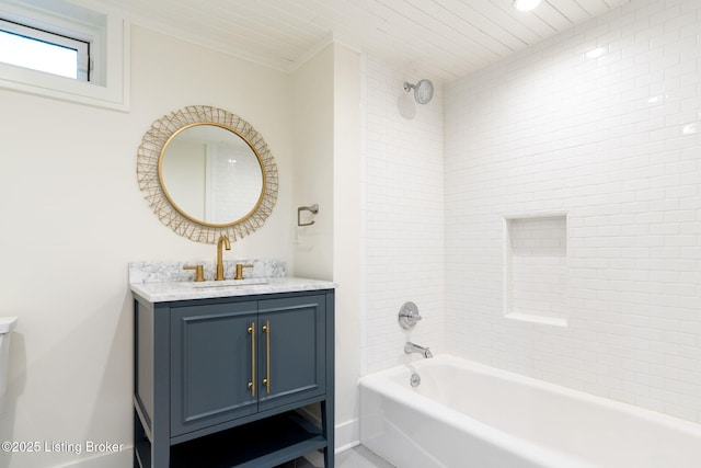 bathroom with tiled shower / bath and vanity