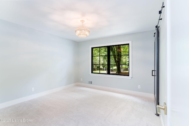 carpeted empty room with a barn door