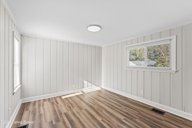 spare room featuring crown molding and hardwood / wood-style floors