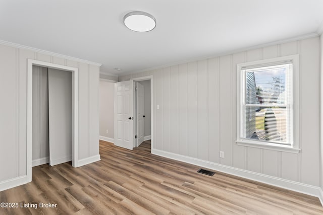 unfurnished bedroom featuring hardwood / wood-style flooring and crown molding