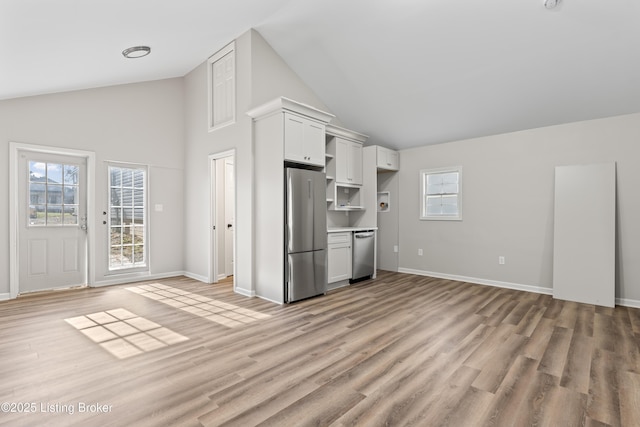 unfurnished living room featuring vaulted ceiling and light wood-type flooring