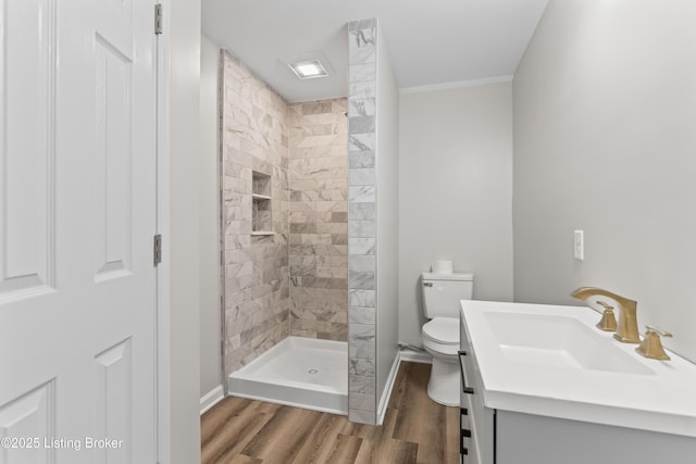 bathroom with tiled shower, vanity, toilet, and hardwood / wood-style floors