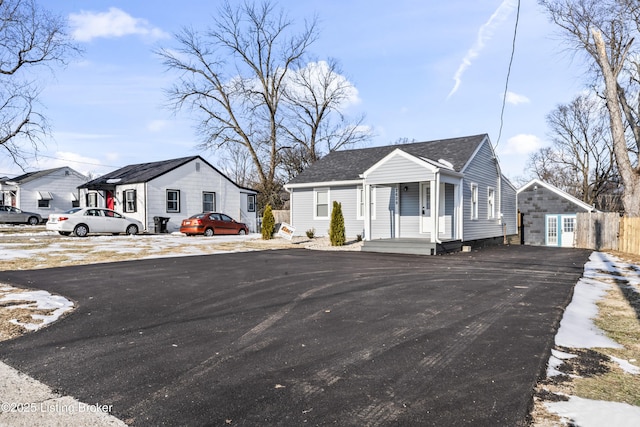 view of front facade with a garage, an outdoor structure, and a porch