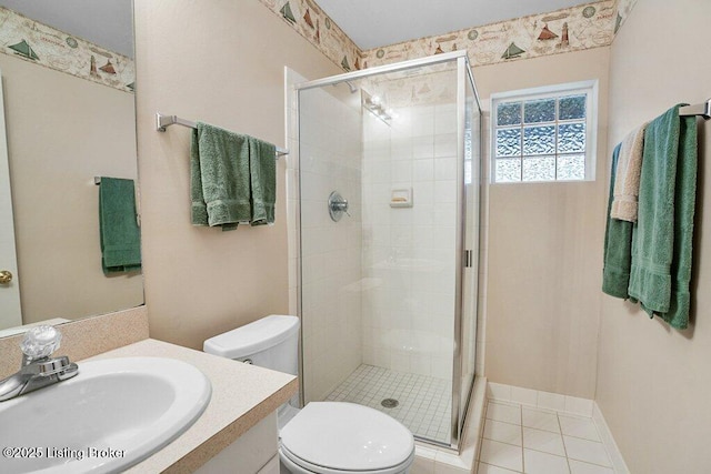 bathroom featuring vanity, a shower with shower door, tile patterned floors, and toilet