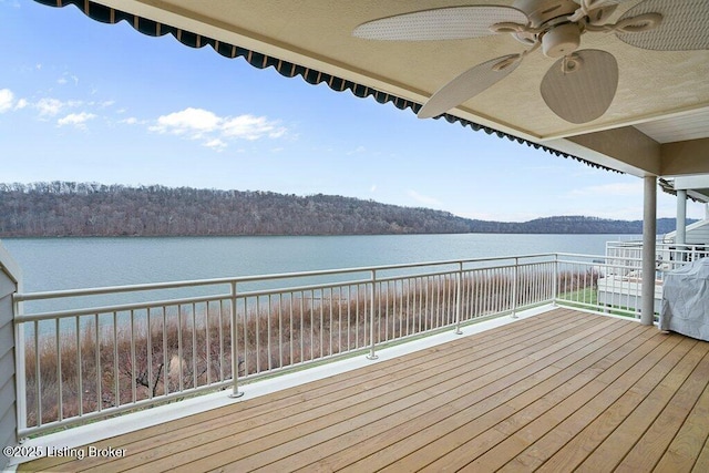 deck featuring ceiling fan and a water view