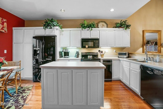 kitchen featuring a center island, sink, white cabinets, and black appliances