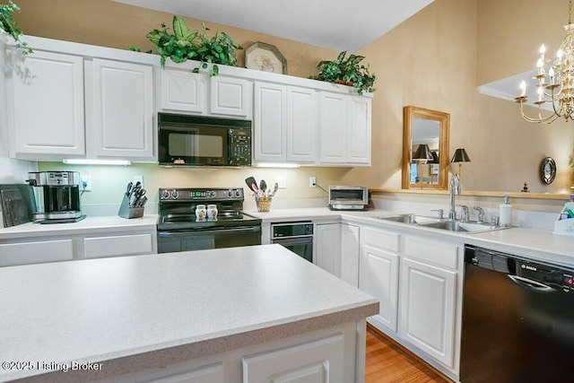 kitchen with sink, pendant lighting, white cabinets, and black appliances