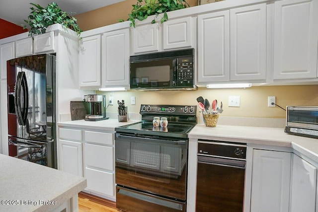 kitchen featuring light hardwood / wood-style flooring, black appliances, and white cabinets