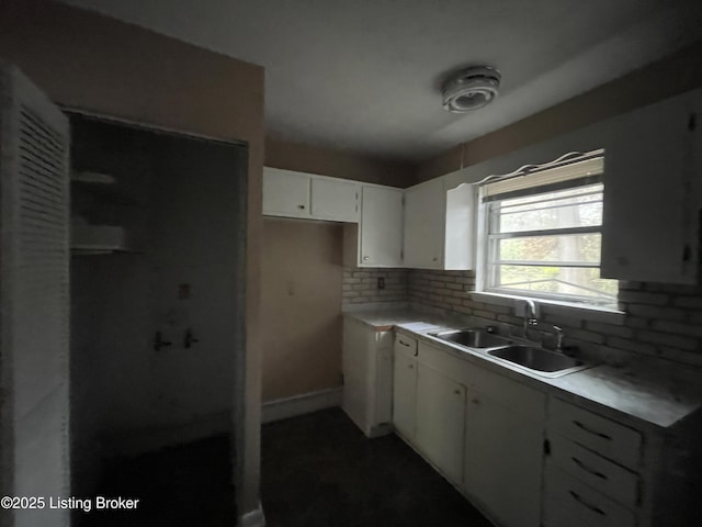 kitchen featuring sink, white cabinets, and decorative backsplash