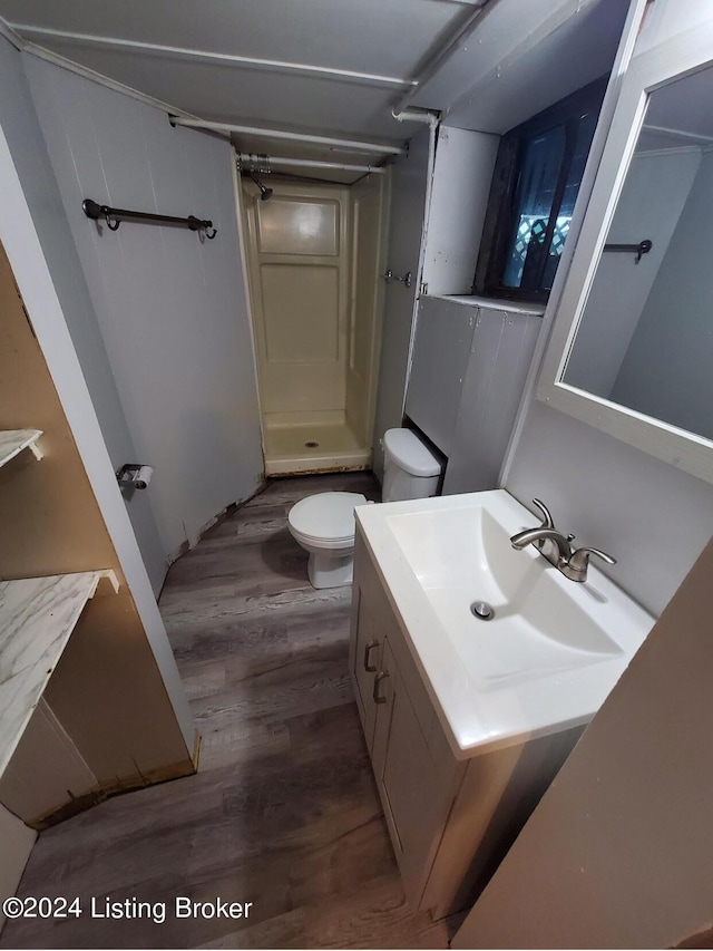 bathroom with vanity, toilet, hardwood / wood-style floors, and a shower