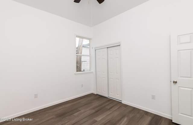 unfurnished bedroom featuring dark wood-type flooring, ceiling fan, and a closet