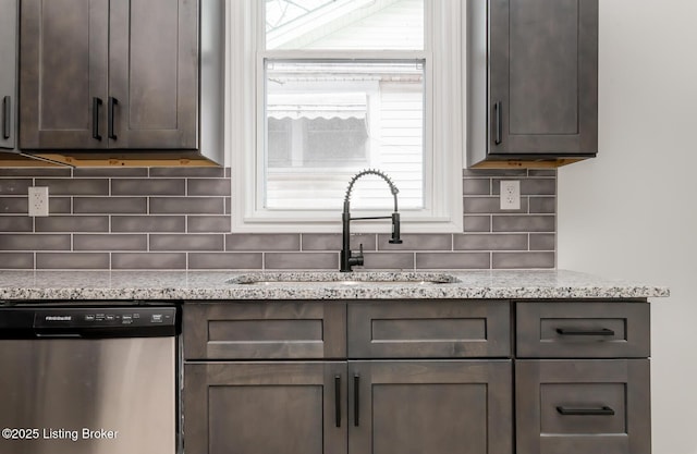 kitchen featuring sink, dark brown cabinets, light stone countertops, decorative backsplash, and stainless steel dishwasher