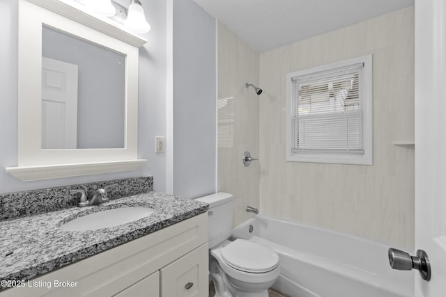 full bathroom with vanity, tiled shower / bath combo, and toilet