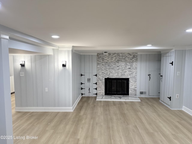 basement featuring a fireplace and light hardwood / wood-style floors