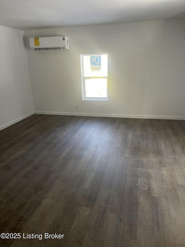 unfurnished room featuring dark wood-type flooring and a wall mounted AC