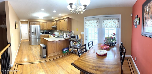 kitchen with electric stove, light hardwood / wood-style flooring, stainless steel fridge, decorative light fixtures, and a chandelier