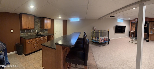 bar with light carpet, backsplash, plenty of natural light, and sink